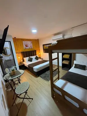 a room with two bunk beds and a table and chairs at The Garden Lleras 10 in Medellín