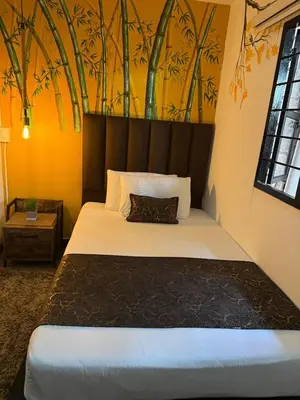 a bedroom with a large bed with a painting on the wall at The Garden Lleras 10 in Medellín