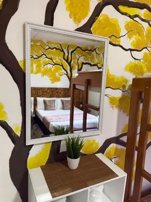 a mirror on a wall with a tree mural at The Garden Lleras 10 in Medellín
