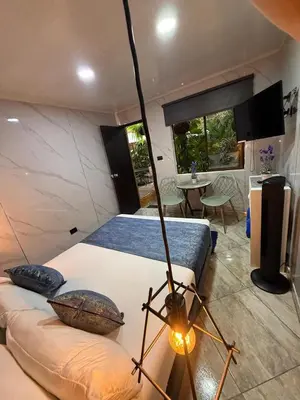 a room with two beds and a table in a room at The Garden Lleras 10 in Medellín
