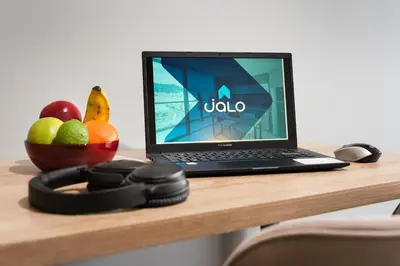 a laptop computer sitting on top of a wooden desk at Go Living and Suites by Jalo in Medellín