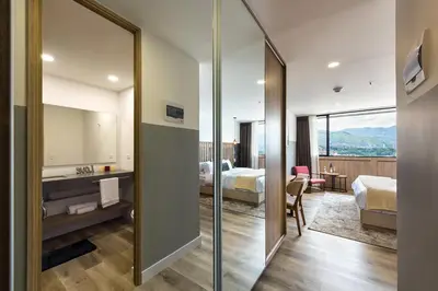 a hotel room with two beds and a mirror at Go Living and Suites by Jalo in Medellín