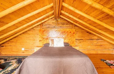 a room with a bed in a wooden attic at Mi lugar secreto in Medellín