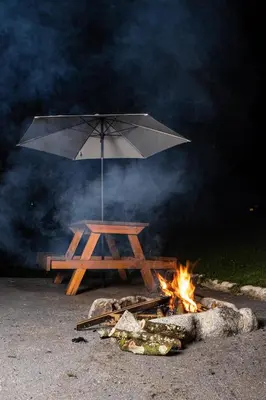 a picnic table with an umbrella over a fire at Mi lugar secreto in Medellín