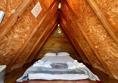 a bed in a wooden room in a tree house at All Natural Glamping in Copacabana