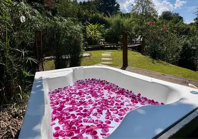 a bath tub filled with pink flowers in a garden at All Natural Glamping in Copacabana