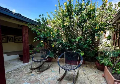 two chairs sitting on a patio next to a tree at All Natural Glamping in Copacabana
