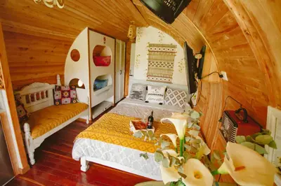 a bedroom with two beds and a table in a room at Glamping Cabañas Sharmont in Guarne