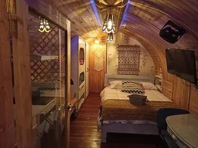 a bedroom with a bed and a tv in a room at Glamping Cabañas Sharmont in Guarne