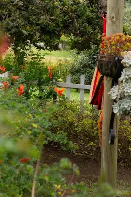 a fence in a garden with flowers and a basket at Glamping Cabañas Sharmont in Guarne