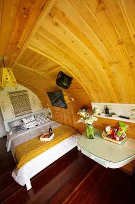 a room with two beds in a wooden ceiling at Glamping Cabañas Sharmont in Guarne