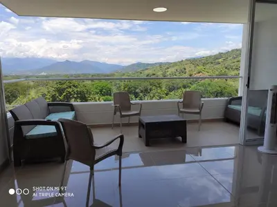 a balcony with chairs and a table and a view at Apartasol Citadela Di Sole 1104 - Santafé de Antioquia in Santa Fe de Antioquia