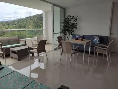 a dining room with a table and chairs and a large window at Apartasol Citadela Di Sole 1104 - Santafé de Antioquia in Santa Fe de Antioquia