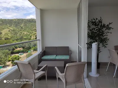 a balcony with a bench and a table and chairs at Apartasol Citadela Di Sole 1104 - Santafé de Antioquia in Santa Fe de Antioquia