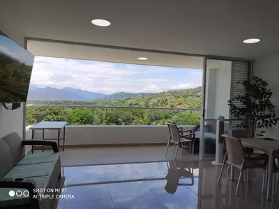 a room with a large window with a view of mountains at Apartasol Citadela Di Sole 1104 - Santafé de Antioquia in Santa Fe de Antioquia