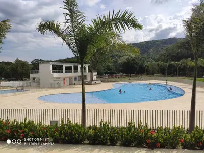 a swimming pool with a palm tree in front of a building at Apartasol Citadela Di Sole 1104 - Santafé de Antioquia in Santa Fe de Antioquia