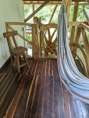 a hammock and a chair in a room at Refugio en el Bosque in Medellín
