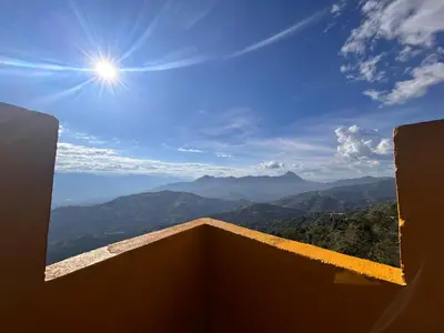 a view of the mountains with the sun in the sky at Hotel Hostal El Castillo Santa in Santa Bárbara