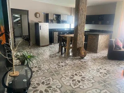 a living room with a table and a kitchen at Hotel Hostal El Castillo Santa in Santa Bárbara