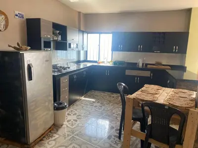 a kitchen with blue cabinets and a table with chairs at Hotel Hostal El Castillo Santa in Santa Bárbara