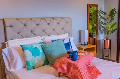 a bed with a table with a plate of food on it at Beautiful Apartment UltraFast Internet /El Poblado in Medellín