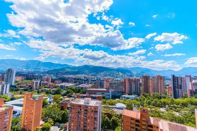 a cityscape of a city with buildings and mountains at Beautiful Apartment UltraFast Internet /El Poblado in Medellín