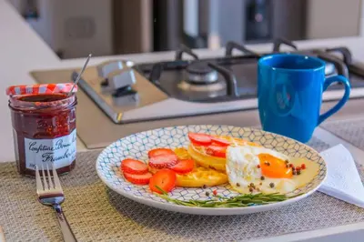 a plate of food with eggs and fruit on a table at Beautiful Apartment UltraFast Internet /El Poblado in Medellín