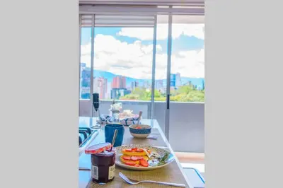 a table with a plate of food on a balcony at Beautiful Apartment UltraFast Internet /El Poblado in Medellín