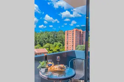 a balcony with a table and glasses of wine at Beautiful Apartment UltraFast Internet /El Poblado in Medellín