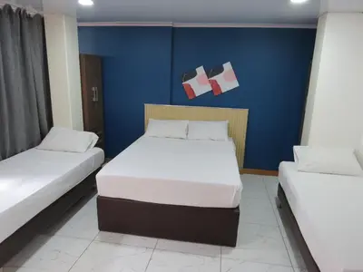 a room with two beds and a blue wall at HOTEL A & A SANTA ALEJANDRIA in Medellín