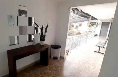 a room with a desk and a view of a balcony at HOTEL A & A SANTA ALEJANDRIA in Medellín