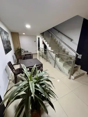 a room with a potted plant and a staircase at Hotel Select Medellin in Medellín