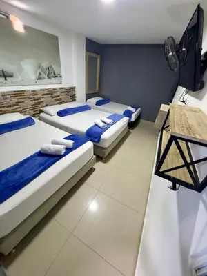 a room with two beds and a flat screen tv at Hotel Select Medellin in Medellín