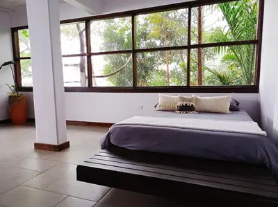a bed in a room with a large window at Casa NATIVO in Jardin