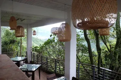 a balcony with tables and chandeliers and a view of the mountains at Casa NATIVO in Jardin