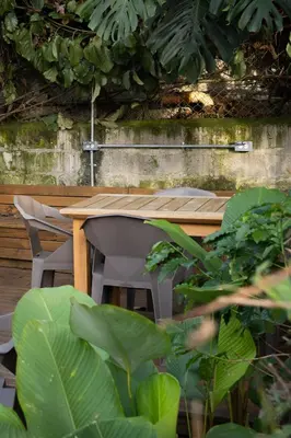 a wooden table with two chairs and plants at Moderna casa pequeña en el Poblado MDE A106 in Medellín