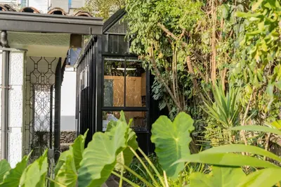 a black front door of a house with plants at Moderna casa pequeña en el Poblado MDE A106 in Medellín