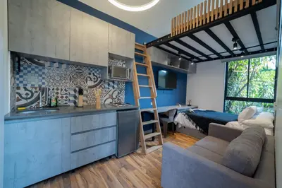 a kitchen and a living room with a loft bed at Moderna casa pequeña en el Poblado MDE A106 in Medellín