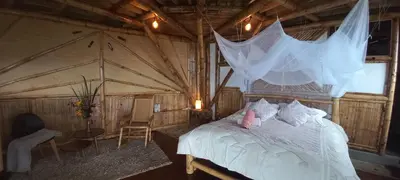 a bedroom with a bed with a net on it at Ecohotel Soplo del Tambo in Cocorná