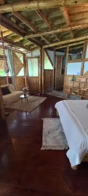 a large room with a bed and a living room at Ecohotel Soplo del Tambo in Cocorná