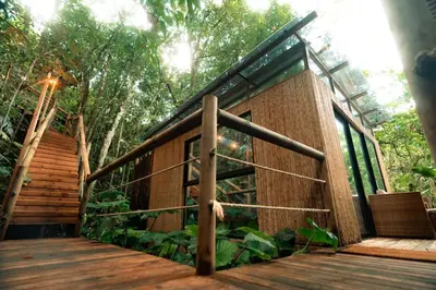 a house in the woods with a wooden deck at BubbleSky Glamping Guatapé in Guatapé