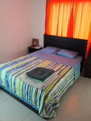 a bedroom with a bed with a colorful striped blanket at Casa 4 in Medellín