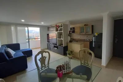 a living room with a glass table and two chairs at Apartamento en Calasanz con piscina y parqueadero in Medellín