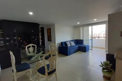 a living room with a blue couch and a table and chairs at Apartamento en Calasanz con piscina y parqueadero in Medellín