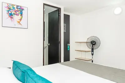 a bedroom with a white bed and a fan at Ayenda Casa San Pablo in Medellín