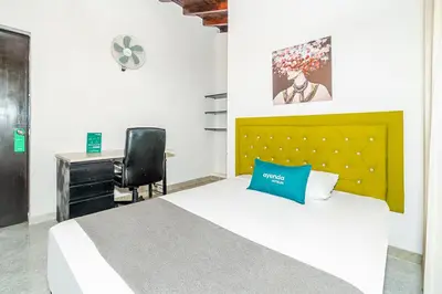 a bedroom with a bed and a desk and a chair at Ayenda Casa San Pablo in Medellín