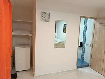 a room with a mirror and a closet and a clock at Hotel Eterna Primavera in Medellín