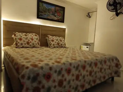 a bedroom with a large bed with two pillows at Hotel Eterna Primavera in Medellín