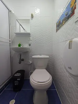 a bathroom with a white toilet and a sink at Hotel Eterna Primavera in Medellín