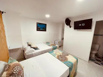 a living room with two couches and a tv at Hotel Eterna Primavera in Medellín